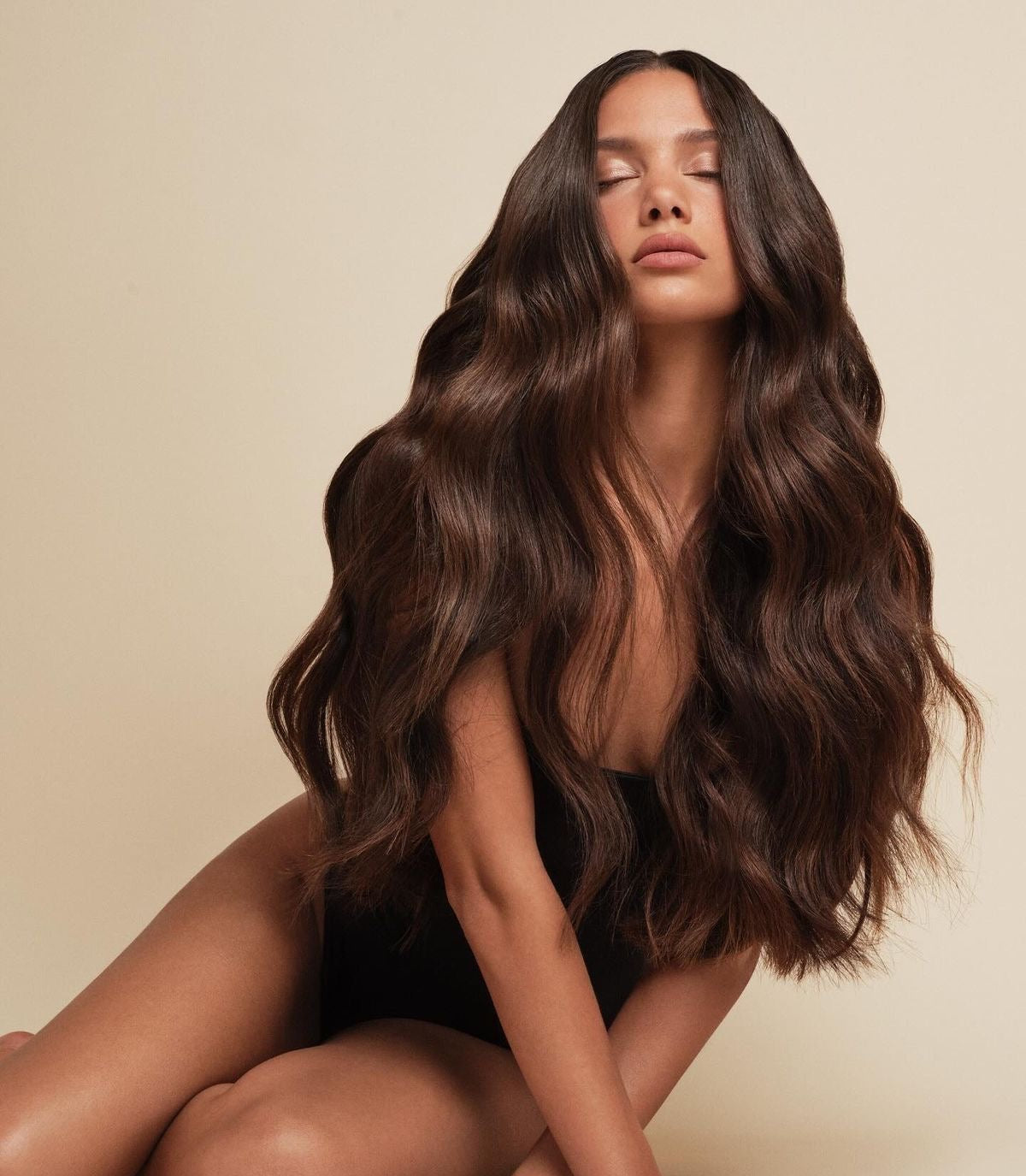 Long, healthy brunette hair with soft waves and a smooth, glossy finish.