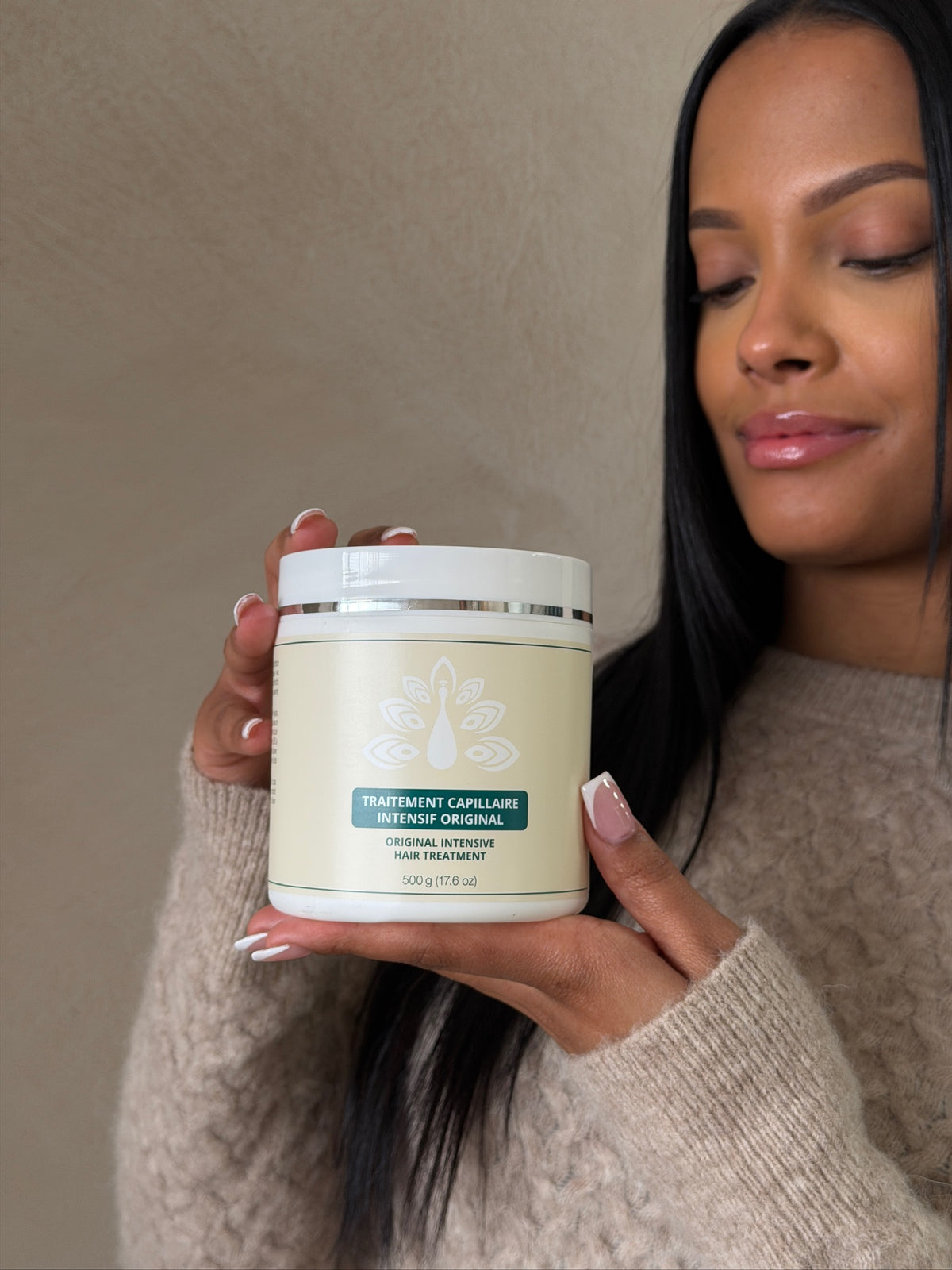 Woman holding the ROYAL Original Intensive Hair Treatment 500 g jar.