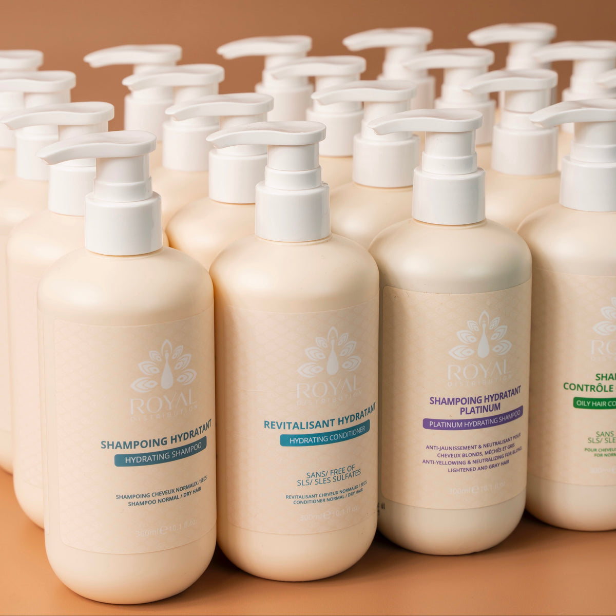 Selection of ROYAL professional hair care products in 300 ml bottles, including hydrating, conditioning, platinum and oil-control formulas, arranged on a warm beige background.