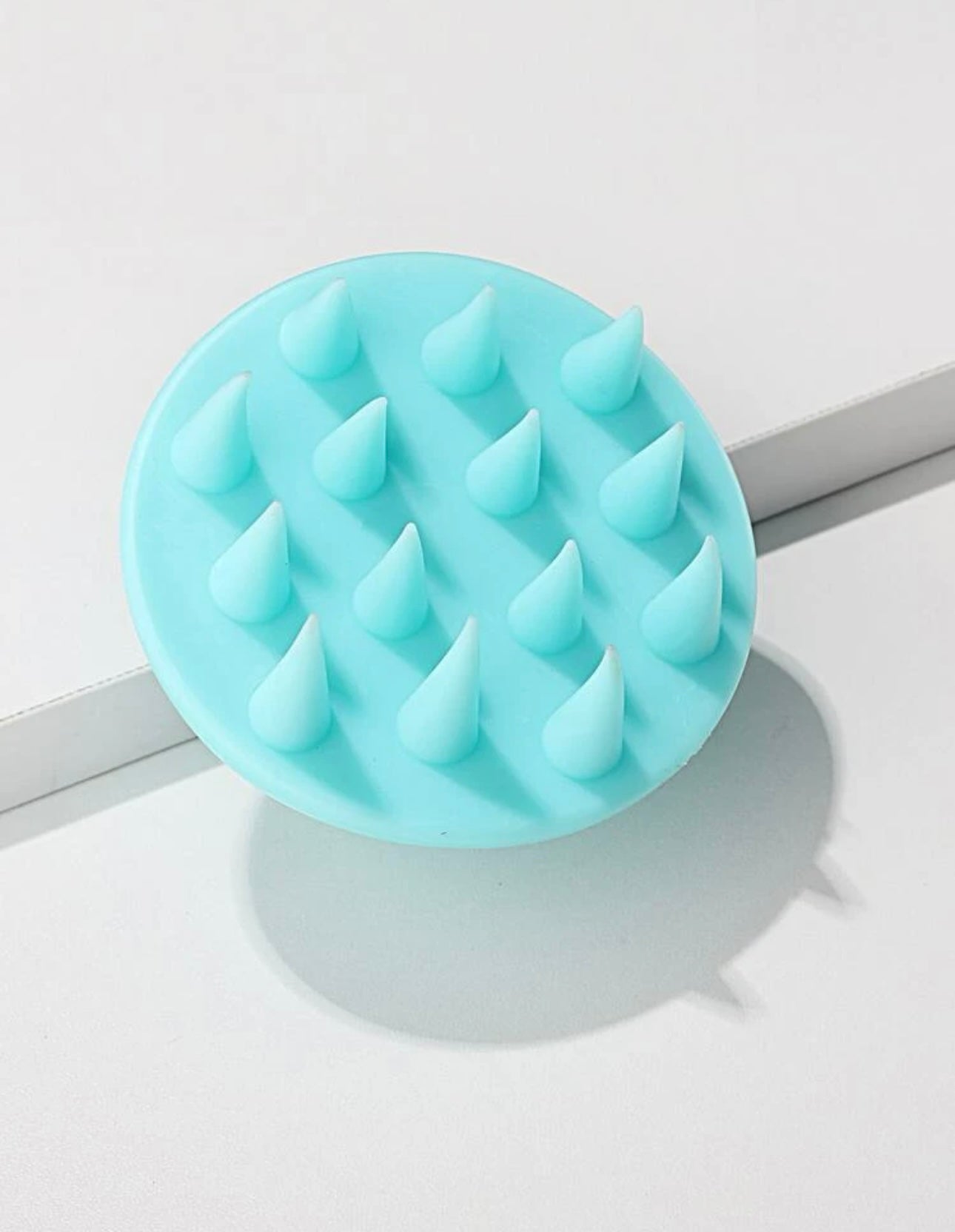 Side view of the Royal blue scalp massage brush, showing its ergonomic handle and flexible bristles for comfortable and effective scalp stimulation.
