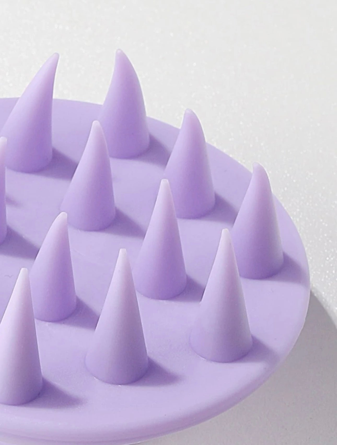 Close-up of the bristles of the Royal purple scalp massage brush, highlighting their flexible tips designed to gently massage the scalp and promote healthy hair.
